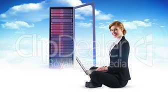 Composite image of redhead businesswoman using her laptop