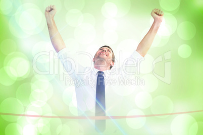 Composite image of businessman crossing the finish line