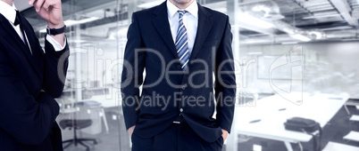 Composite image of smiling businessman standing with hands in po