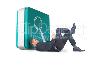 Composite image of businessman lying on the floor reading book