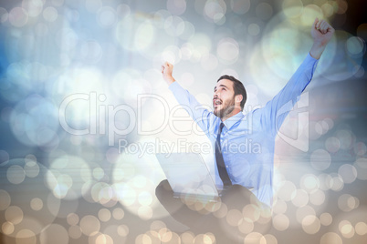 Composite image of excited cheering businessman sitting using hi