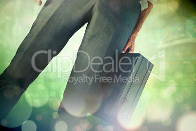 Composite image of businessman holding briefcase