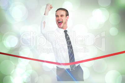 Composite image of businessman crossing the finish line while cl