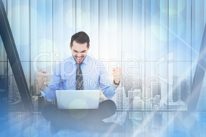 Composite image of businessman sitting with his laptop cheering