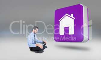 Composite image of cheerful businessman sitting on the floor usi