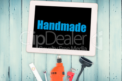 Handmade against tools and tablet on wooden background