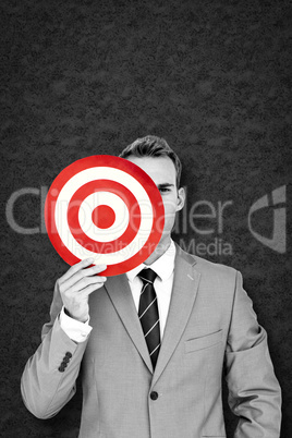 Composite image of businessman holding target