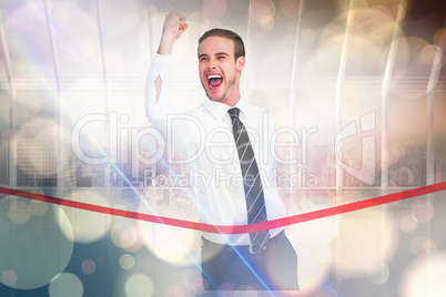 Composite image of businessman crossing the finish line while cl