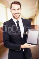 Composite image of smiling businessman showing his tablet pc