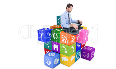 Composite image of cheerful businessman sitting on the floor usi