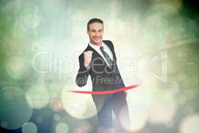 Composite image of happy businessman crossing the finish line