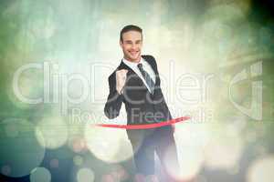 Composite image of happy businessman crossing the finish line