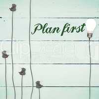 Plan first against light bulbs on wooden background