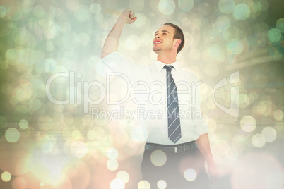 Composite image of businessman cheering with clenched fist