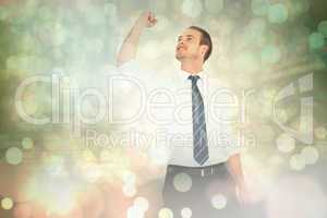 Composite image of businessman cheering with clenched fist