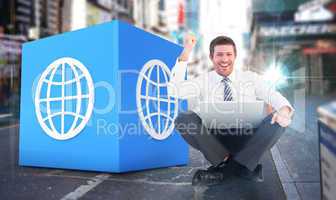 Composite image of businessman using laptop and cheering