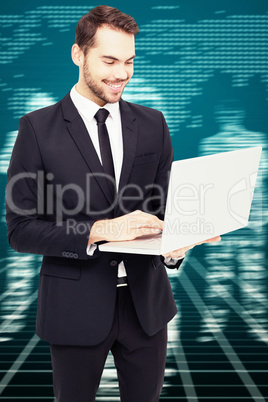 Composite image of smiling businessman standing and using laptop