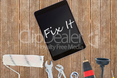 Fix it against tools and tablet on wooden background