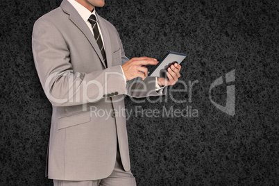 Composite image of businessman using tablet pc