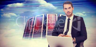 Composite image of cheerful businessman with laptop using smartp