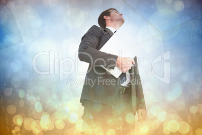 Composite image of businessman looking up holding laptop Composite image of businessman looking up holding laptop