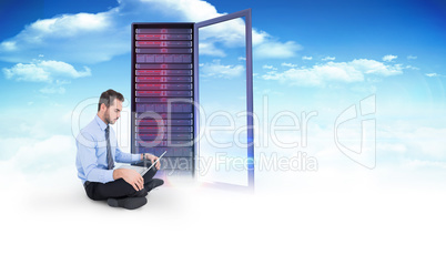 Composite image of cheerful businessman sitting on the floor usi