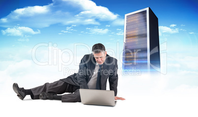 Composite image of mature businessman sitting using laptop