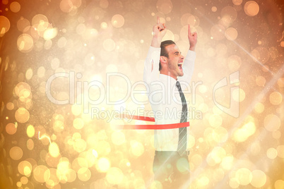 Composite image of happy businessman crossing the finish line an