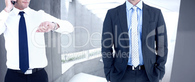 Composite image of businessman on the phone looking at his wrist