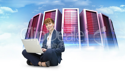 Composite image of businesswoman using laptop