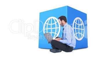 Composite image of businessman sitting on the floor using his la