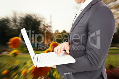 Composite image of businessman holding laptop