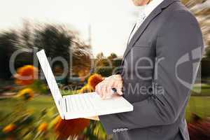 Composite image of businessman holding laptop