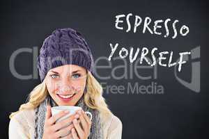 Composite image of pretty blonde in winter fashion holding mug