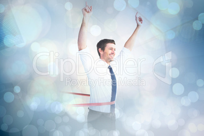 Composite image of businessman crossing the finish line