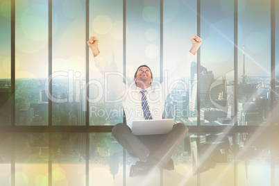 Composite image of excited cheering businessman sitting using hi