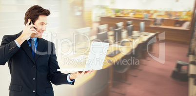 Composite image of businessman making a phone call while using a