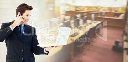 Composite image of businessman making a phone call while using a