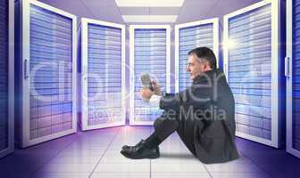 Composite image of mature businessman sitting using tablet