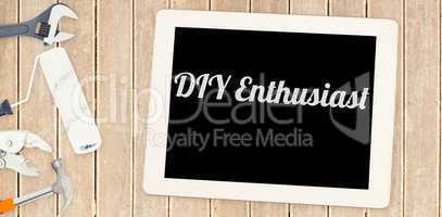 Diy enthusiast against tools and tablet on wooden background
