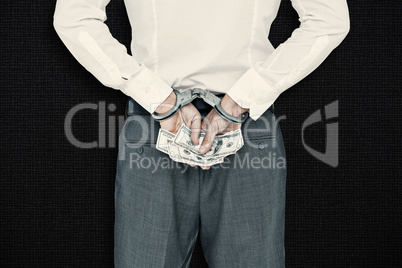 Composite image of businessman in handcuffs holding bribe