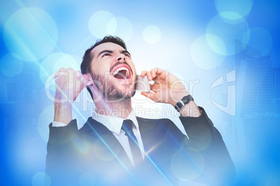 Composite image of cheering businessman in suit on the phone