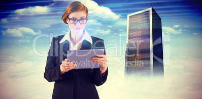 Composite image of redhead businesswoman using her tablet pc