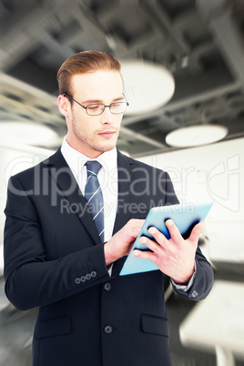 Composite image of unsmiling businessman using tablet pc