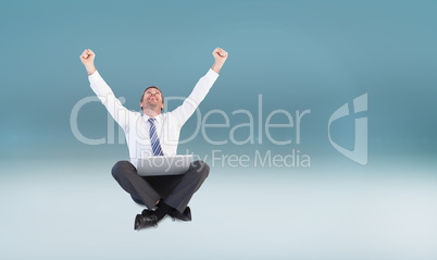 Composite image of excited cheering businessman sitting using hi