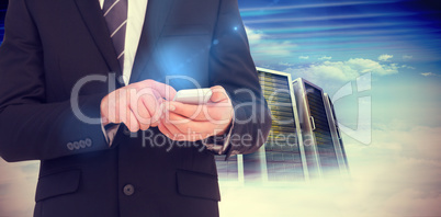 Composite image of businessman sending a text message