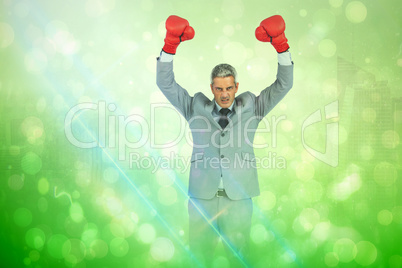 Composite image of furious businessman posing with red boxing gl