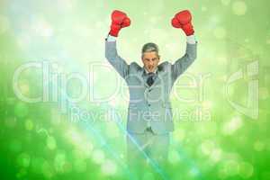 Composite image of furious businessman posing with red boxing gl