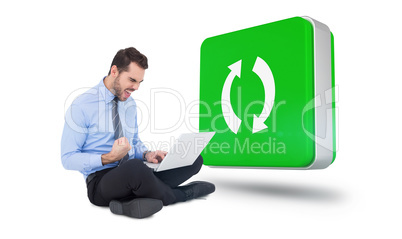 Composite image of cheering businessman sitting using his laptop