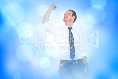 Composite image of businessman cheering with clenched fist